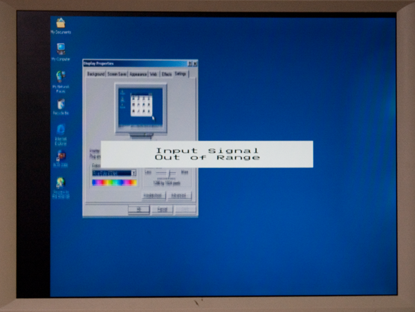 A blurry off center desktop with an error message that reads "Input signal Out of Range"